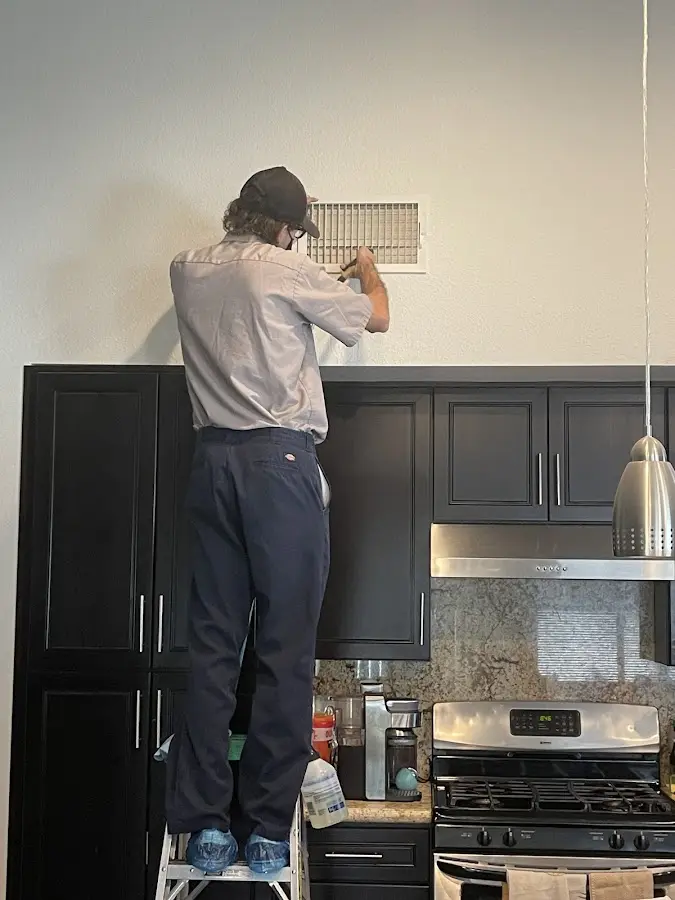 Technician inspecting an air vent during HVAC service in Grand Island